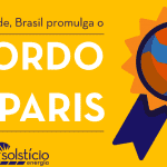 Retângulo amarelo com um badge na porção direita. Ele é como uma medalha que tem como pin o planeta Terra. O laço é roxo e laranja. Na porção esquerda, o texto Em solenidade, Brasil promulga o Acordo de Paris.